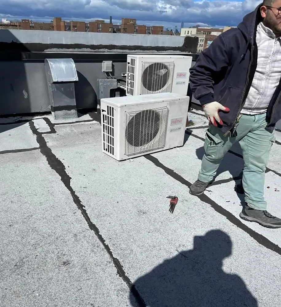 Chill Factor technician on a NYC rooftop with newly serviced condenser units