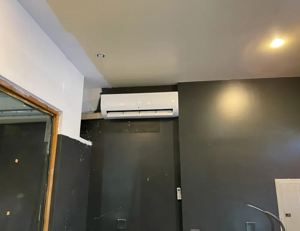 Mini-split unit on an exposed brick brownstone wall